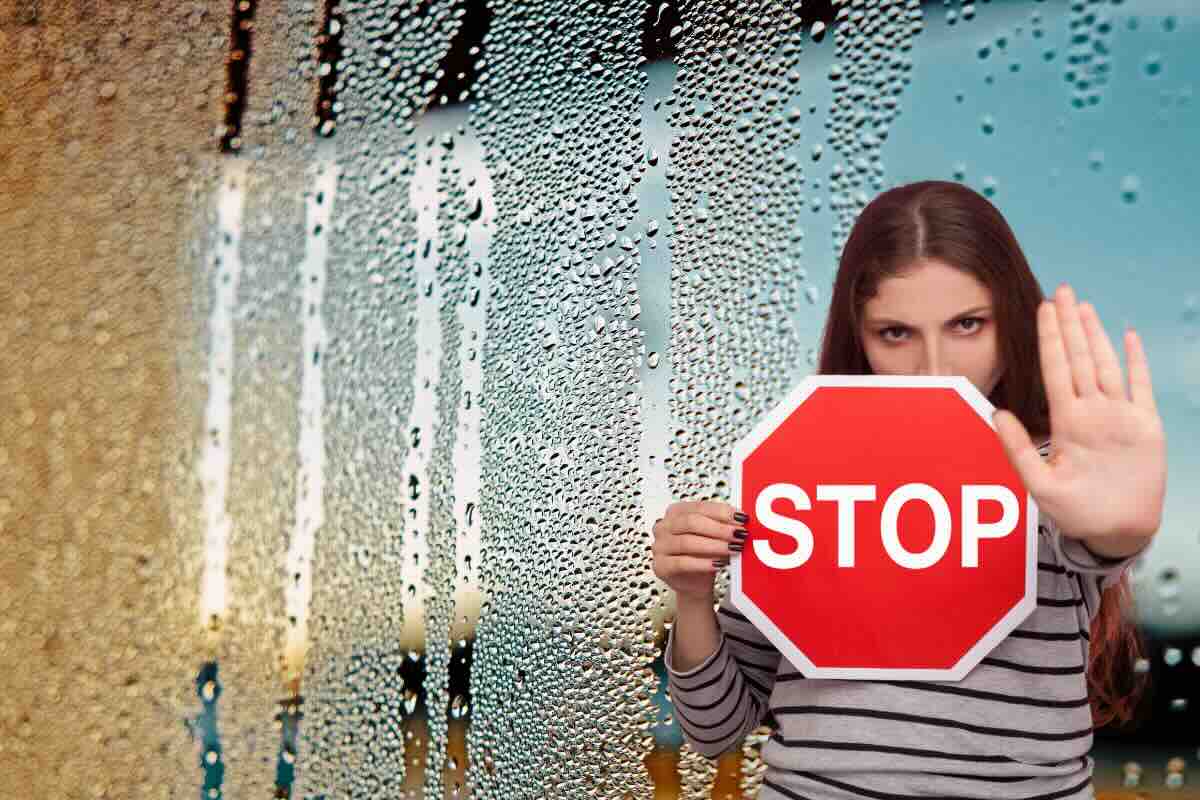 umidità vetro e donna con segnale stop