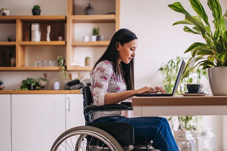 donna in carrozzella lavora con pc
